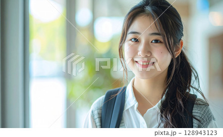 自然光の入る部屋で微笑む若い女性学生のリラックスシーン 128943123