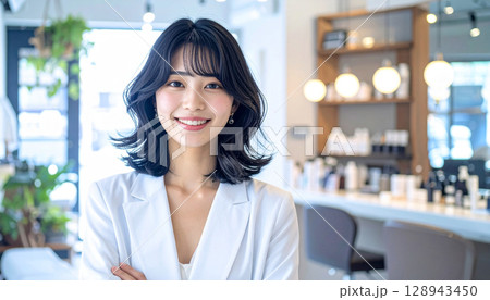 清潔なオフィスで笑顔でPCを操作する若い女性会社員 128943450
