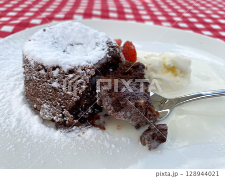 French dessert chocolate fondant with strawberries and ice cream. 128944021