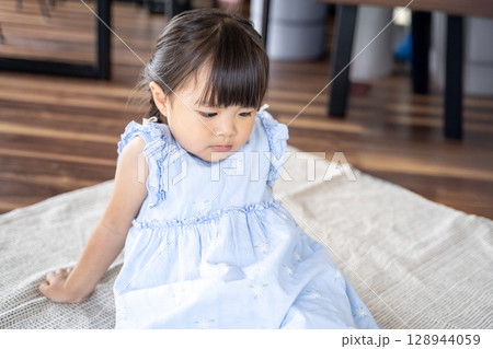 床に座って不機嫌な幼い女の子 128944059