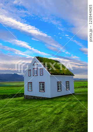 Beautiful wooden house with green roof in Iceland. Beautiful wooden house with green roof in Iceland. 128944065