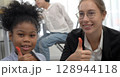 African kid with caucasian teacher diversity fun interactive learning environment school 128944118
