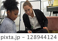 African kid with caucasian teacher diversity fun interactive learning environment school 128944124