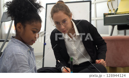 African kid with caucasian teacher diversity fun interactive learning environment school African kid with caucasian teacher diversity fun interactive learning environment school 128944124