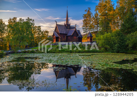 Garmo Stave Church in Lillehammer, Norway, reflected in a pond at sunset 128944205