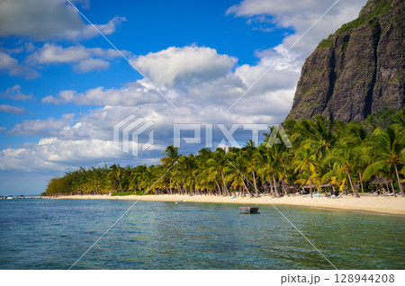 Tropical beach with boats, palm trees, and Le Morne Brabant mountain, Mauritius 128944208