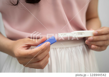 Asian holding pregnancy test for female of ovulation day, fetus, maternity, childbirth, birth control. Asian holding pregnancy test for female of ovulation day, fetus, maternity, childbirth, birth control. 128944542