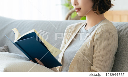 ソファに座って読書をする女性 ソファに座って読書をする女性 128944785