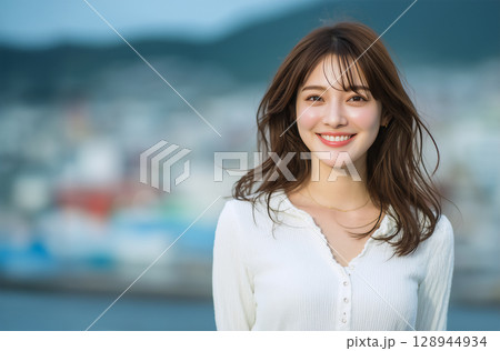 自然な笑顔が魅力的な若い女性の屋外ポートレート 自然な笑顔が魅力的な若い女性の屋外ポートレート 128944934