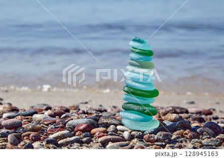 pyramid of balancing glass stones on the seashore. 128945163