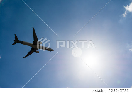 青空の下を上昇していく旅客機 ロンドン郊外のヒースロー空港近くにて 青空の下を上昇していく旅客機 ロンドン郊外のヒースロー空港近くにて 128945786