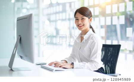 パソコンで仕事する女性会社員 128945989