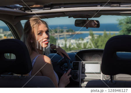 Young driver woman behind steering wheel 128946127