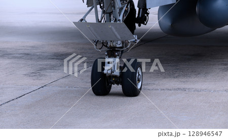 Close up of modern aircraft military fighter jet. Close up Jet parts such as landing gear engine nacelles weapon pods and cockpit with visible pilots showing defense technology and aircraft design. Close up of modern aircraft military fighter jet. Close up Jet parts such as landing gear engine nacelles weapon pods and cockpit with visible pilots showing defense technology and aircraft design. 128946547
