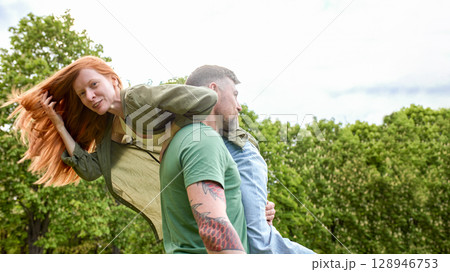 Playful couple having fun outdoors in a green park 128946753