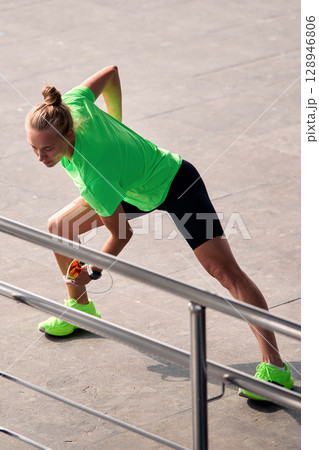 Athletic woman stretching outdoors in vibrant sportswear during a fitness session Athletic woman stretching outdoors in vibrant sportswear during a fitness session 128946806