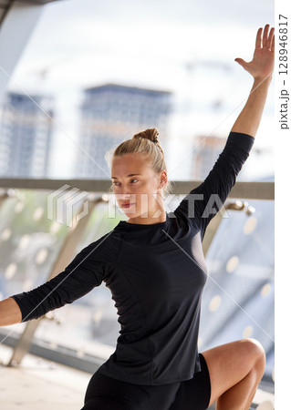 Young woman practicing fitness stretching poses in an urban environment Young woman practicing fitness stretching poses in an urban environment 128946817