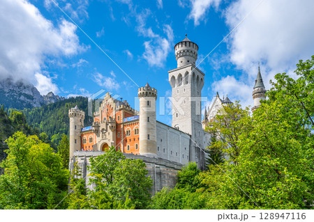 Neuschwanstein Castle rises majestically amidst lush greenery in Bavaria, Germany. 128947116