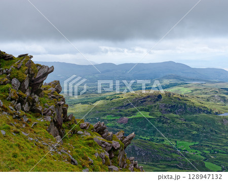 Views from high above the scenic landscape of the Coomloughra Horseshoe trail in County Kerry, Ireland, on a cloudy day. 128947132