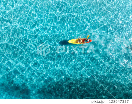 Aerial view of a kayakers paddling through vibrant blue waters 128947337