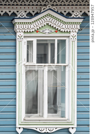 Fragment of the facade of a wooden russian house of the 19th century with carved decor based on folk architecture 128947957