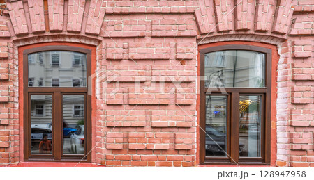 Two windows of the old mansion 19 century with brown bricks wall Two windows of the old mansion 19 century with brown bricks wall 128947958