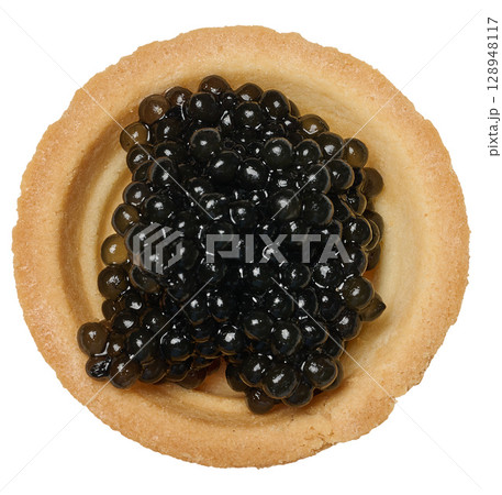 Close up top view of black caviar neatly served in one round mini tartlet, isolated background Close up top view of black caviar neatly served in one round mini tartlet, isolated background 128948117