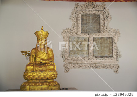 A golden Chinese-style Buddha statue is decorated in the Sala Rai at Wat Pho, one of the largest and oldest temples in Bangkok and a popular destination for both Thai and foreign tourists. 128949329