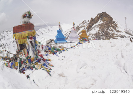 Prayer flags at a small religious site at Khardung La. This pass is located in the Ladakh mountains north of Leh and connects the Indus and Shyok river valleys and is the highest motorable road. 128949540