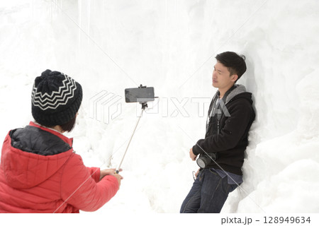 Asian tourists take photos with their mobile phones at Khardung La, the highest motorable road in the world. Located in India. Asian tourists take photos with their mobile phones at Khardung La, the highest motorable road in the world. Located in India. 128949634