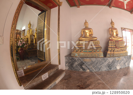 Row of sitting golden Buddha at cloister in Wat Phra Chetuphon or Wat Pho. Which is one of the largest and oldest temples and is popular with both Thai and foreign tourists. 128950020
