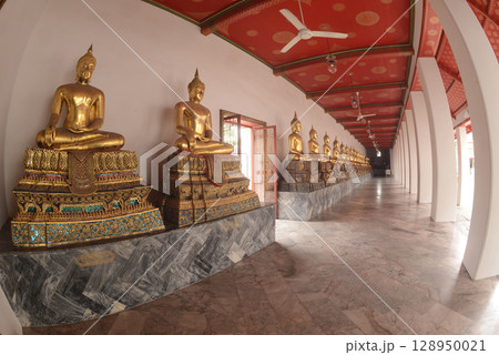 Row of sitting golden Buddha at cloister in Wat Phra Chetuphon or Wat Pho. Which is one of the largest and oldest temples and is popular with both Thai and foreign tourists. 128950021