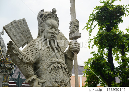 Chinese guardian statue at the gate of Wat Pho Which is one of the largest and oldest temples in Bangkok and is popular with both Thai and foreign tourists. 128950143