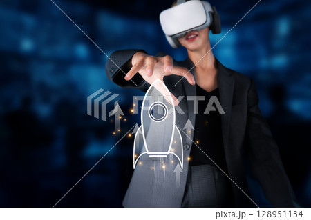 Business Professional in Virtual Reality Holding a Rocket Icon for Startup Success and Innovative Growth in a Technological Environment XDMCP Business Professional in Virtual Reality Holding a Rocket Icon for Startup Success and Innovative Growth in a Technological Environment XDMCP 128951134