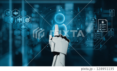 Futuristic Robot Hand Interacting with Digital User Interface in High-Tech Environment Representing Artificial Intelligence and Human Interaction. Auvana 128951135