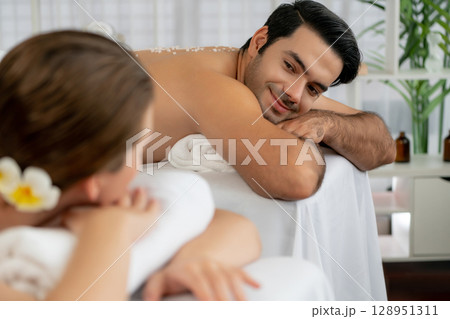 Blissful couple customer having exfoliation treatment in luxury spa. Quiescent Blissful couple customer having exfoliation treatment in luxury spa. Quiescent 128951311