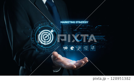 Businessman presenting digital marketing strategy with futuristic graphics and target icon, highlighting innovative business solutions in modern technology. Qubit 128951382