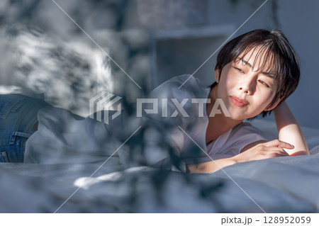ベッドに横たわる女性 エモい斜光 ベッドに横たわる女性 エモい斜光 128952059