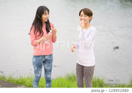 水辺で水分補給する二人の女性 水辺で水分補給する二人の女性 128952880