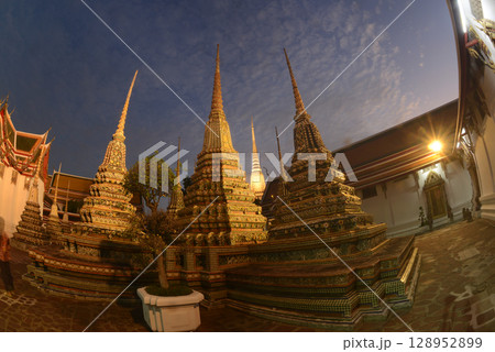 Scenic sunset time of Classic Thai architecture with pagoda in Wat Phra Chetuphon or Wat Pho. Which is one of the largest and oldest temples and is popular with both Thai and foreign tourists. Scenic sunset time of Classic Thai architecture with pagoda in Wat Phra Chetuphon or Wat Pho. Which is one of the largest and oldest temples and is popular with both Thai and foreign tourists. 128952899