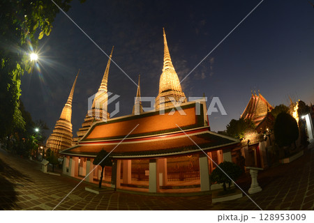 Scenic night time of Classic Thai architecture with pagoda in Wat Phra Chetuphon or Wat Pho. Which is one of the largest and oldest temples and is popular with both Thai and foreign tourists. Scenic night time of Classic Thai architecture with pagoda in Wat Phra Chetuphon or Wat Pho. Which is one of the largest and oldest temples and is popular with both Thai and foreign tourists. 128953009