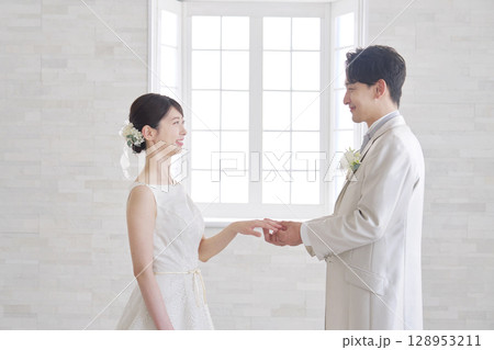 新婦の指に指輪をつける新郎 新婦の指に指輪をつける新郎 128953211