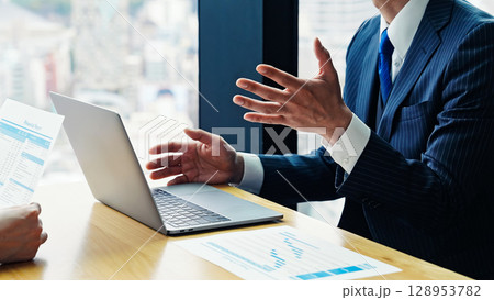 オフィスでPC画面を見ながら面談するビジネスパーソンのグループ オフィスでPC画面を見ながら面談するビジネスパーソンのグループ 128953782