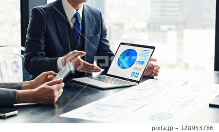 オフィスでPC画面を見ながら面談するビジネスパーソンのグループ オフィスでPC画面を見ながら面談するビジネスパーソンのグループ 128953786