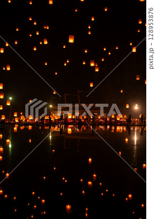 Fire Lanterns Floating up into the sky is reflection in the water at night at Loi Krathong Festival Travel Destinations Of Chiang Mai, Thailand. Fire Lanterns Floating up into the sky is reflection in the water at night at Loi Krathong Festival Travel Destinations Of Chiang Mai, Thailand. 128953876