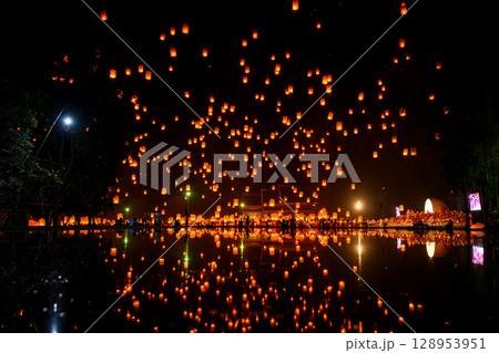Fire Lanterns Floating up into the sky is reflection in the water at night at Loi Krathong Festival Travel Destinations Of Chiang Mai, Thailand. Fire Lanterns Floating up into the sky is reflection in the water at night at Loi Krathong Festival Travel Destinations Of Chiang Mai, Thailand. 128953951