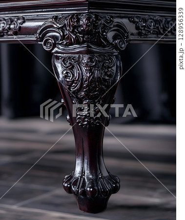 Black table with a carved leg and a black background 128956339