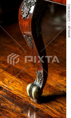 Wooden table with a leg that has a gold trim 128956361