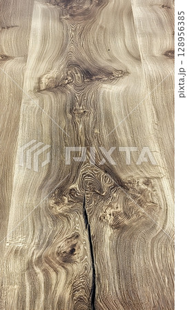 Piece of wood with a large crack running through it 128956385
