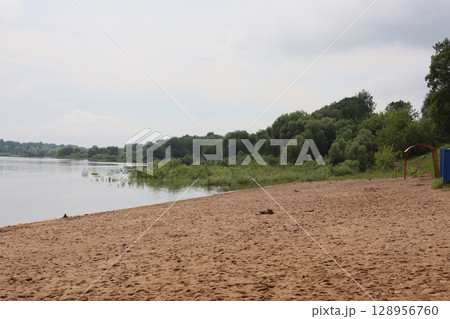 A Serene Beach Scene Featuring Calm Waters and Beautiful Lush Greenery All Around it A Serene Beach Scene Featuring Calm Waters and Beautiful Lush Greenery All Around it 128956760